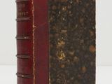 an old book sitting on top of a table next to a white table