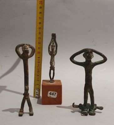 three bronze figurines of a man and a woman standing on a skateboard