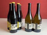 quatre bouteilles de vin sont alignées sur une table