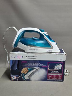 un fer à repasser à vapeur bleu et blanc posé sur une boîte