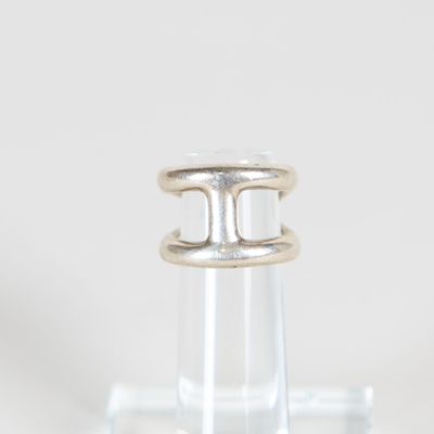 un gros plan d'une bague en argent posée sur une bouteille transparente