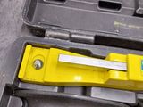 a tool in a tool case with a yellow handle