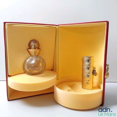 un flacon de parfum posé dans une boîte sur une table