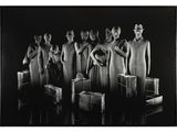 photographie en noir et blanc d'un groupe de mannequins posant devant un fond noir