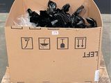 un carton rempli de sacs poubelles noirs posé sur une palette