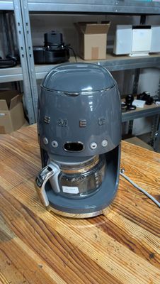 a coffee maker sitting on a wooden table in a kitchen