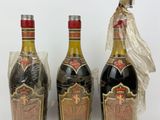 three bottles of liquor sitting next to each other on a white surface