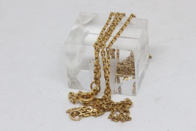 une petite boîte transparente à laquelle est attachée une chaîne en or