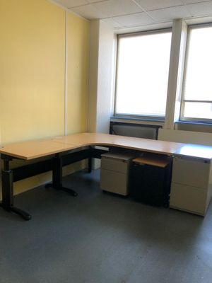 un bureau dans une pièce vide dotée de deux fenêtres