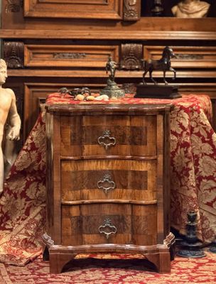 une petite commode surmontée d'une statuette