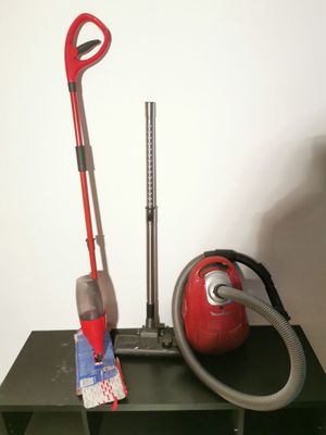 a red vacuum and a red vacuum cleaner on a green table