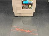 a nintendo game sitting on a table next to a book
