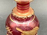 a red and gold vase with a gold top