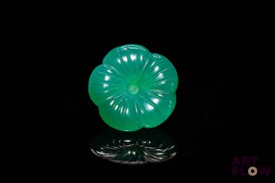 an image of a green flower shaped object on a black surface