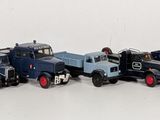 many toy trains lined up in a row on a white surface