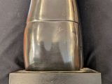 silver statue of a woman with her hands on her head