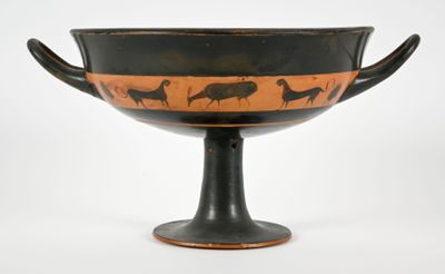 an old black and orange vase with animals on it on a white surface