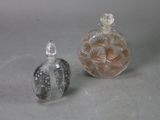two small glass bottles sitting next to each other on a table