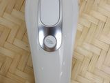 a white electric shaver sitting on top of a wooden floor