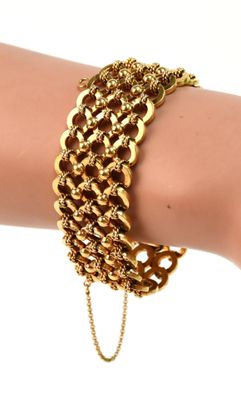 un gros plan sur la main d'une personne portant un bracelet à chaîne en or
