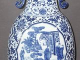 un vase bleu et blanc sur lequel est représenté un homme et une femme