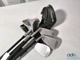 a bag of golf clubs sitting on a table next to a pair of irons