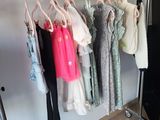 a lot of clothes hanging on a rack in a room