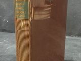 an old book sitting on a table with a yellow ribbon