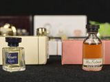 several bottles of perfume are lined up on a black surface