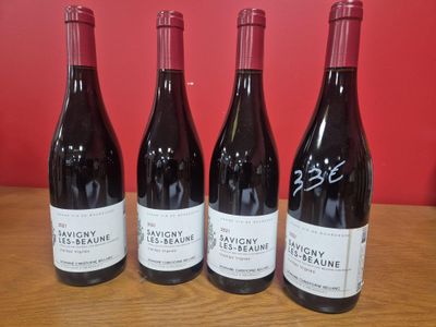 trois bouteilles de vin sont alignées sur une table en bois