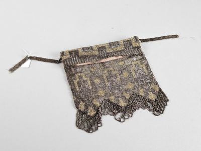 un gros plan d'un petit sac muni d'un cordon, posé sur une surface blanche