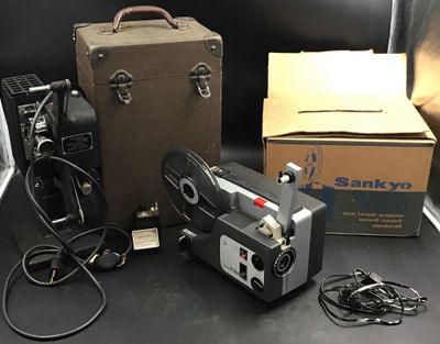 un appareil photo et une valise posés sur une table à côté d'une boîte