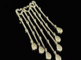 a close up of a gold necklace on a black background