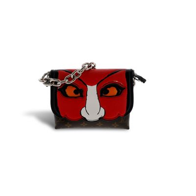 un gros plan d'un sac à main rouge et noir orné d'un chat