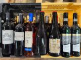 many bottles of wine sitting on a shelf next to each other