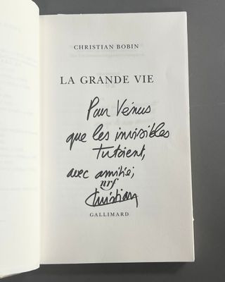un livre ouvert avec une écriture dessus, posé sur une table
