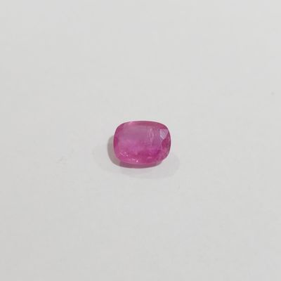 a pink sapphire stone on a white surface