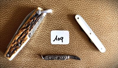 a picture of a knife and a pocket knife on a brown leather surface