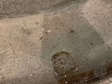 a close up of a silver plate with a face on it