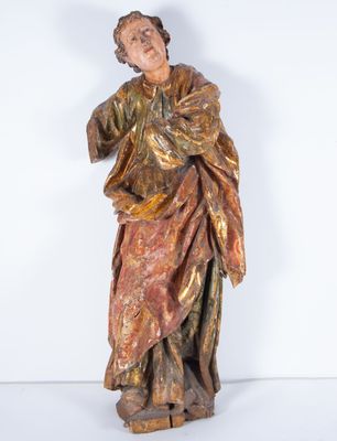 une vieille statue en bois représentant un homme tenant un livre