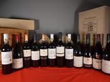 many bottles of wine sitting on a table with a red cloth