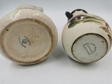 pair of ceramic vases with birds on them sitting on a white surface
