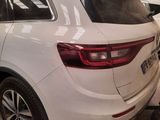 the rear end of a white car parked in a garage