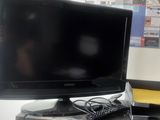 a black computer monitor sitting on a desk in a room