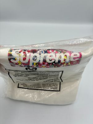 Quelqu'un tient un sac de bonbons sur lequel est inscrit le mot « Supreme ».