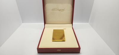 un lingot d'or dans un écrin rouge posé sur une surface blanche