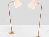 a pair of brass floor lamps with white shades