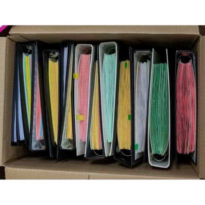 a box filled with lots of different colored files of paper