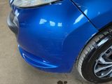 a close up of a blue car that has been dented