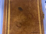 an old book sitting on top of a blue table next to a pair of shoes